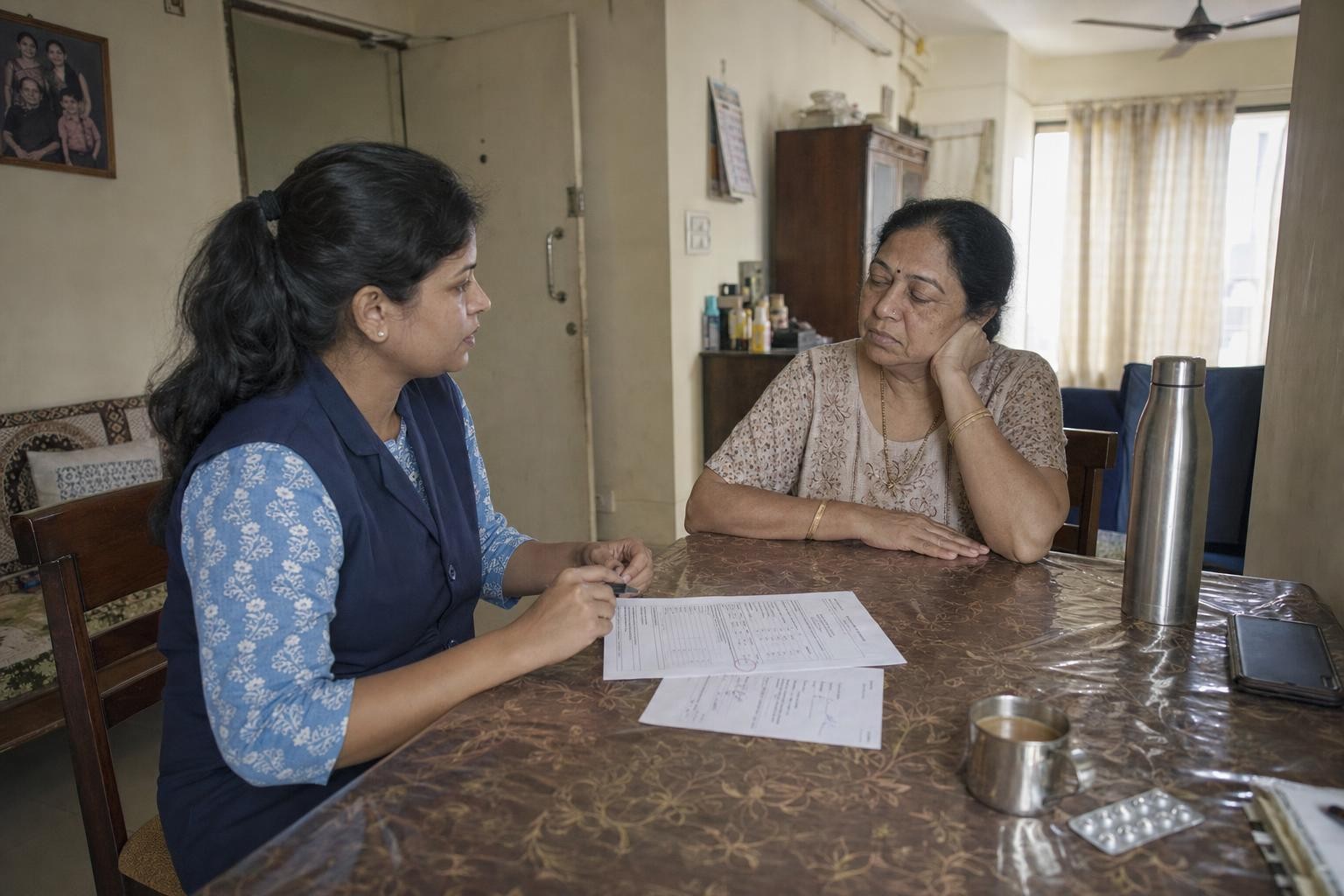 A blood report and a handwritten prescription slip laid on a table beside a cup of tea